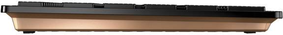 A mechanical keyboard viewed from the side. The housing is black with a copper-coloured base.