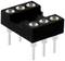 A black, rectangular base with six round recesses and six metal pins underneath, possibly an electronic component.