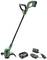 A green cordless lawn trimmer with charging station and battery. The trimmer has an ergonomic handle and is suitable for light gardening tasks.