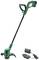 Green electric lawn trimmer with a long handle and black grip, with a charger beside it. Suitable for garden work.