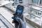 A hand in a grey glove holds a Bosch laser distance measuring device in front of a construction site backdrop. The device displays 'Alignment'.