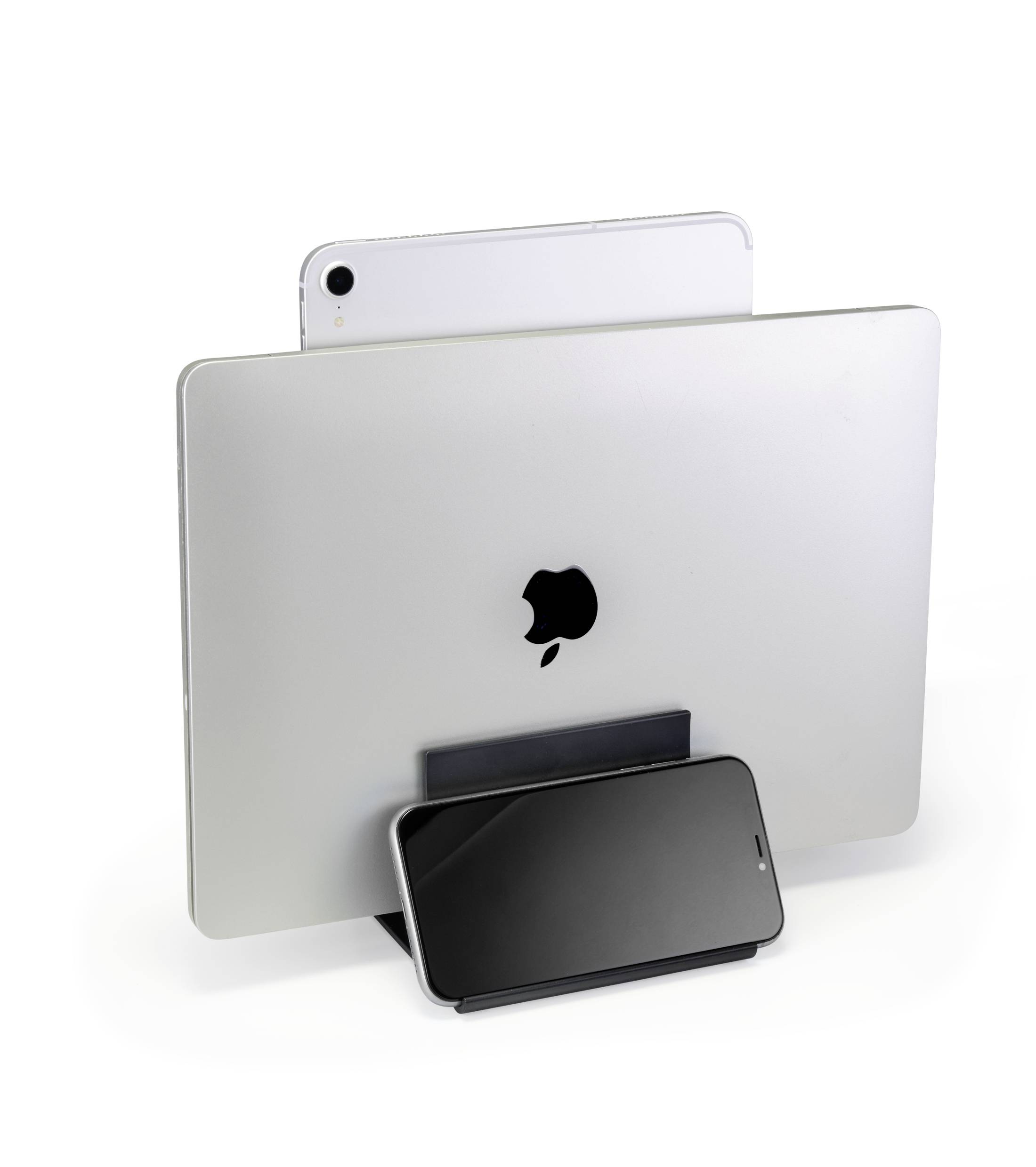 A laptop, tablet and smartphone are standing vertically side by side in a narrow stand, with their screens not visible.