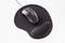 A black computer mouse is resting on an ergonomic mousepad with a wrist rest.