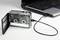 A cassette recorder is connected to a laptop via a USB cable, symbolising the digitalisation of analogue audio formats.