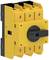 Yellow three-pole load disconnector in an industrial setting, with a black handle for electrical safety applications.