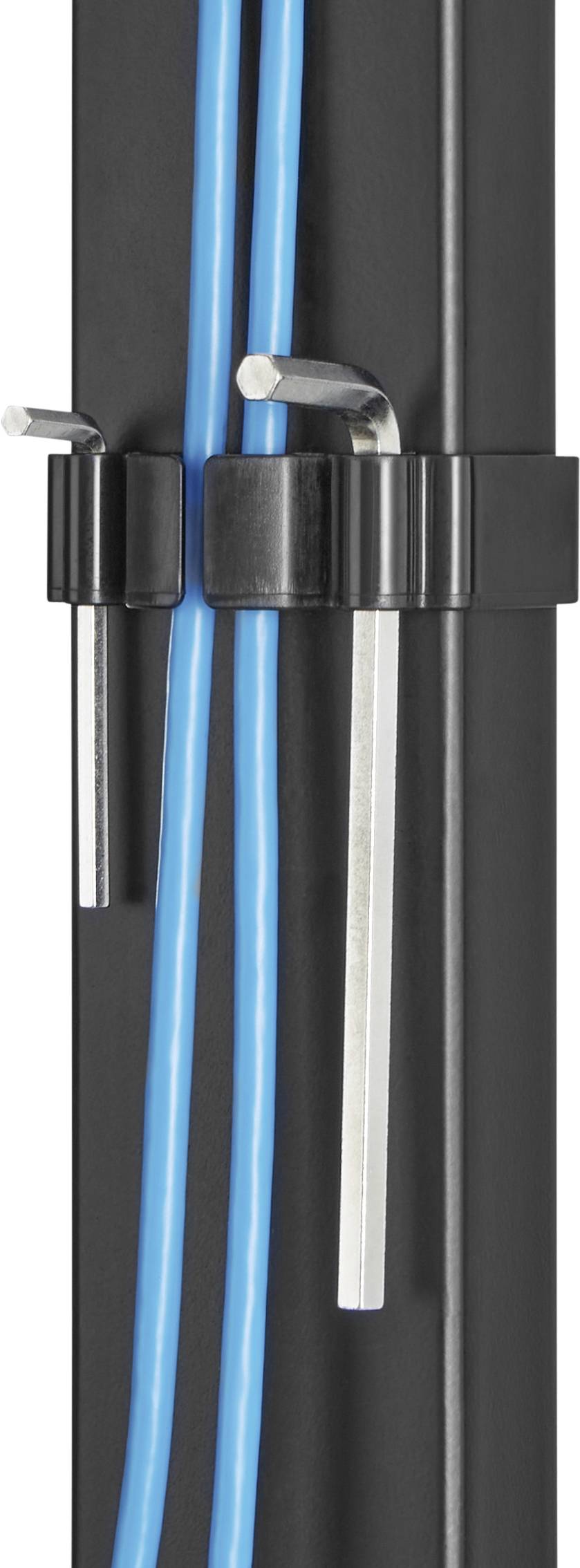A black cable management clip on a table leg holds two blue cables and two hexagonal keys.