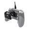 Rear view of a grey games controller with a charging cable connected and an additional device on the back.