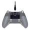 Rear view of a grey game controller with a USB cable plugged in. The controller has two large buttons on the back.