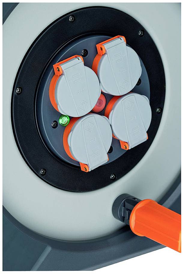 The image shows four plug sockets and a cable winder arranged in a circular configuration with an orange handle.
