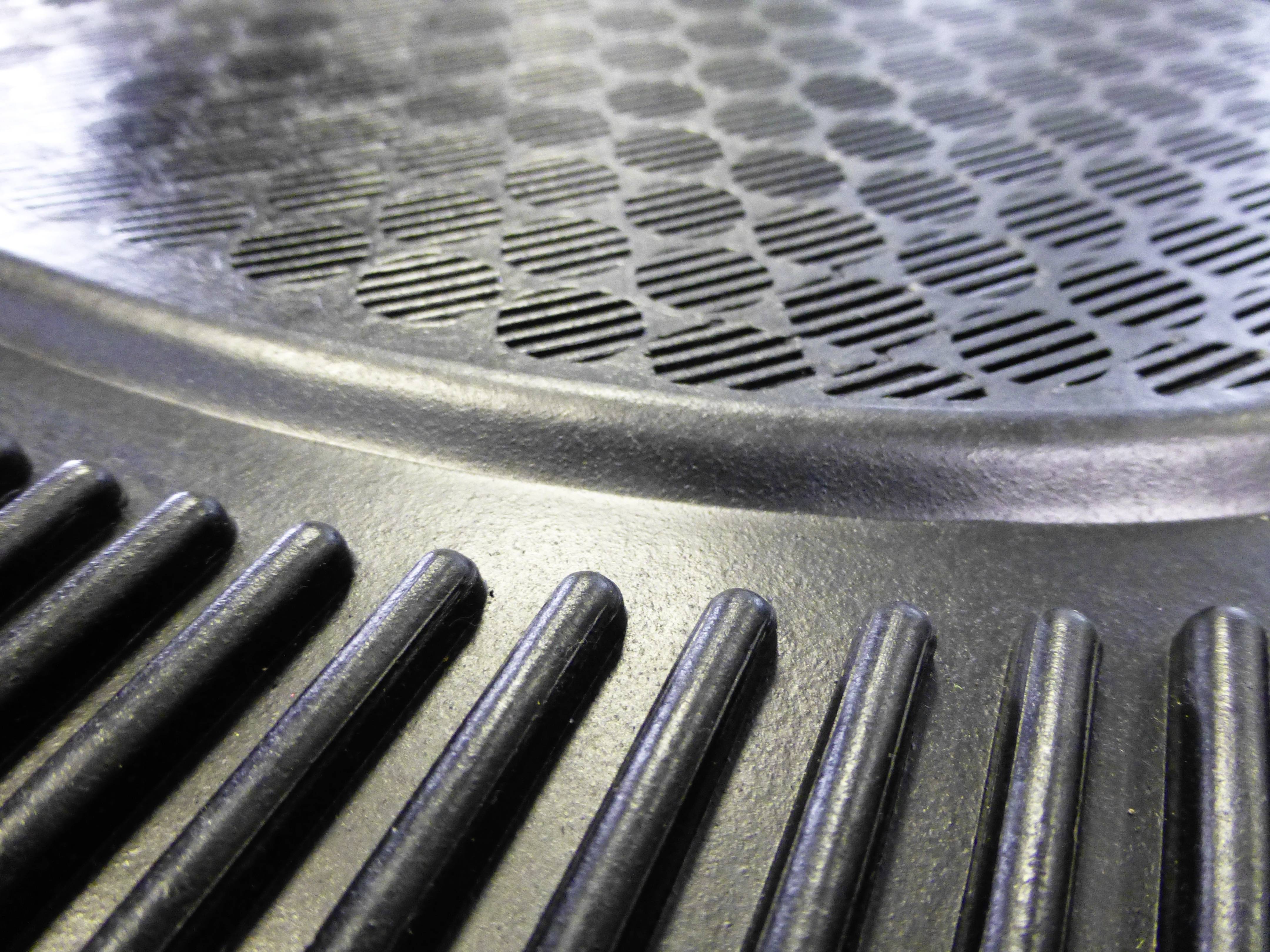 Close-up of a round, disc-shaped metal surface with radial grooves and a structured, perforated centre.