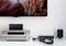Living room with entertainment electronics: an amplifier with speakers, headphones and a television showing a mountain landscape image.