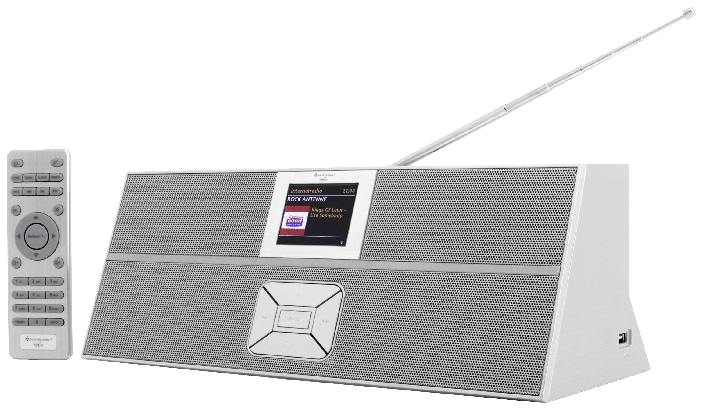 A silver portable radio with a digital display and an extendable aerial. A remote control is placed beside it.