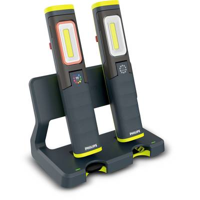 Two portable LED work lights from Philips are standing in a charging station. They are black with yellow accents and have display indicators.