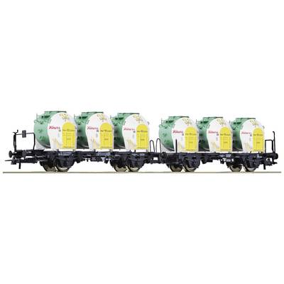 Train with several yellow tanker carriages, bearing a sunflower and the word 'seed oil', on a railway track.