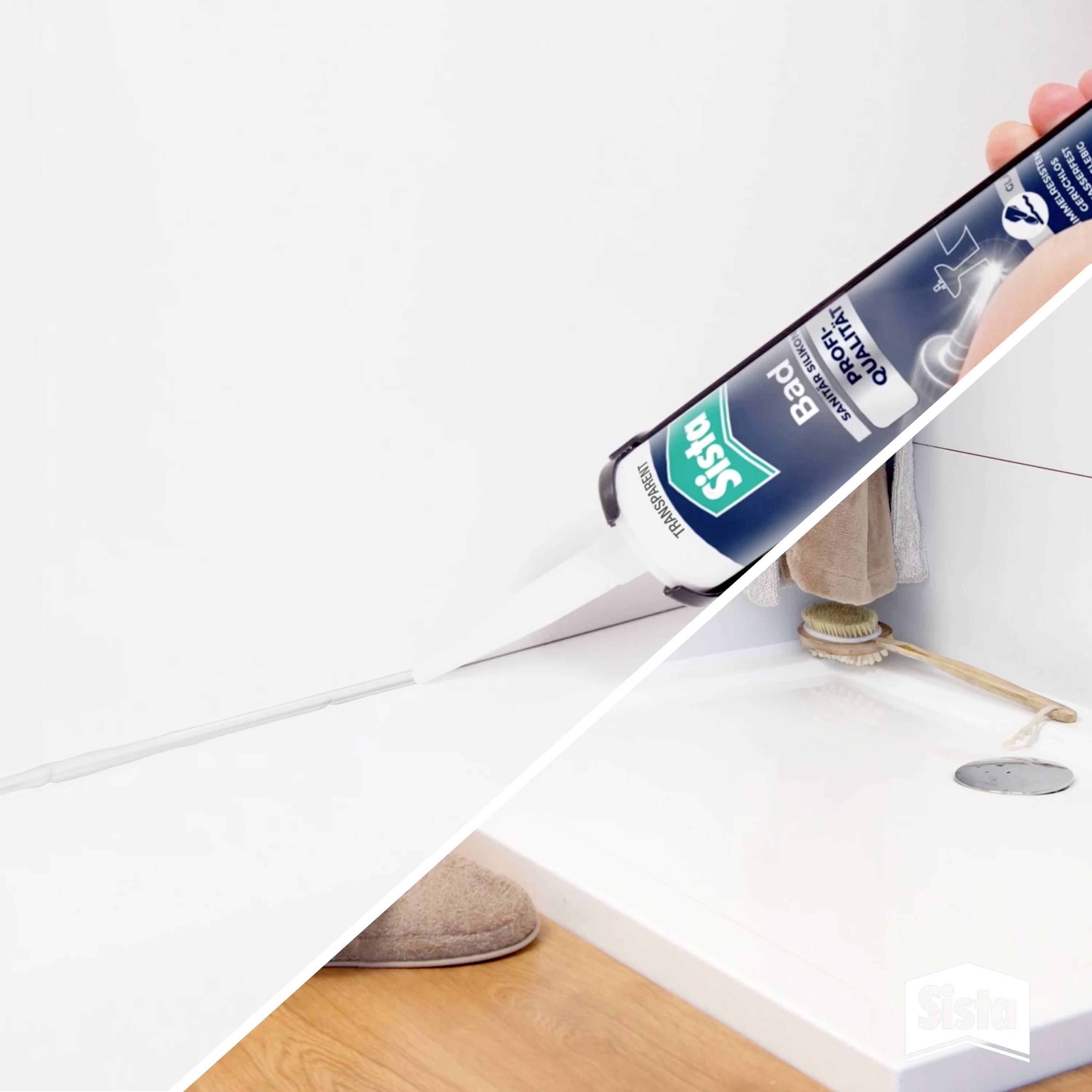 A hand is using a silicone cartridge to seal the gap between the wall and the bath edge. Tiles are visible in the background.