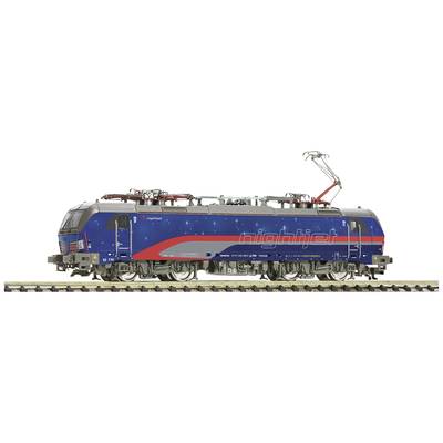 A model of a night train in blue with a red stripe and star design on a section of track.