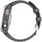 A digital wristwatch with a metal casing and black silicone strap, side view with visible control button.