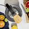 Freshly pressed juice with a citrus press, surrounded by sliced oranges, limes and grapefruit.
