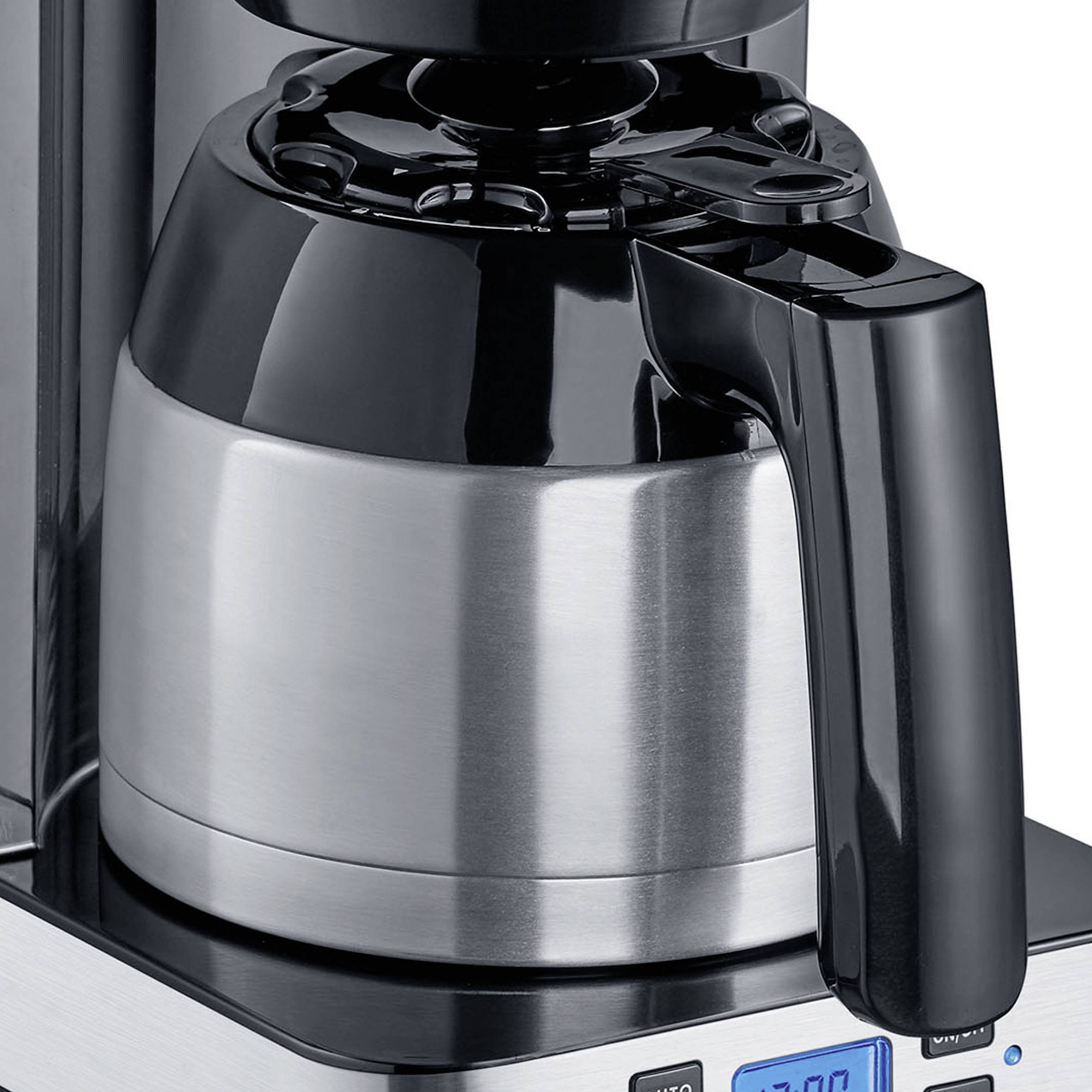 Silver coffee machine with glass carafe and black handle on digital base.