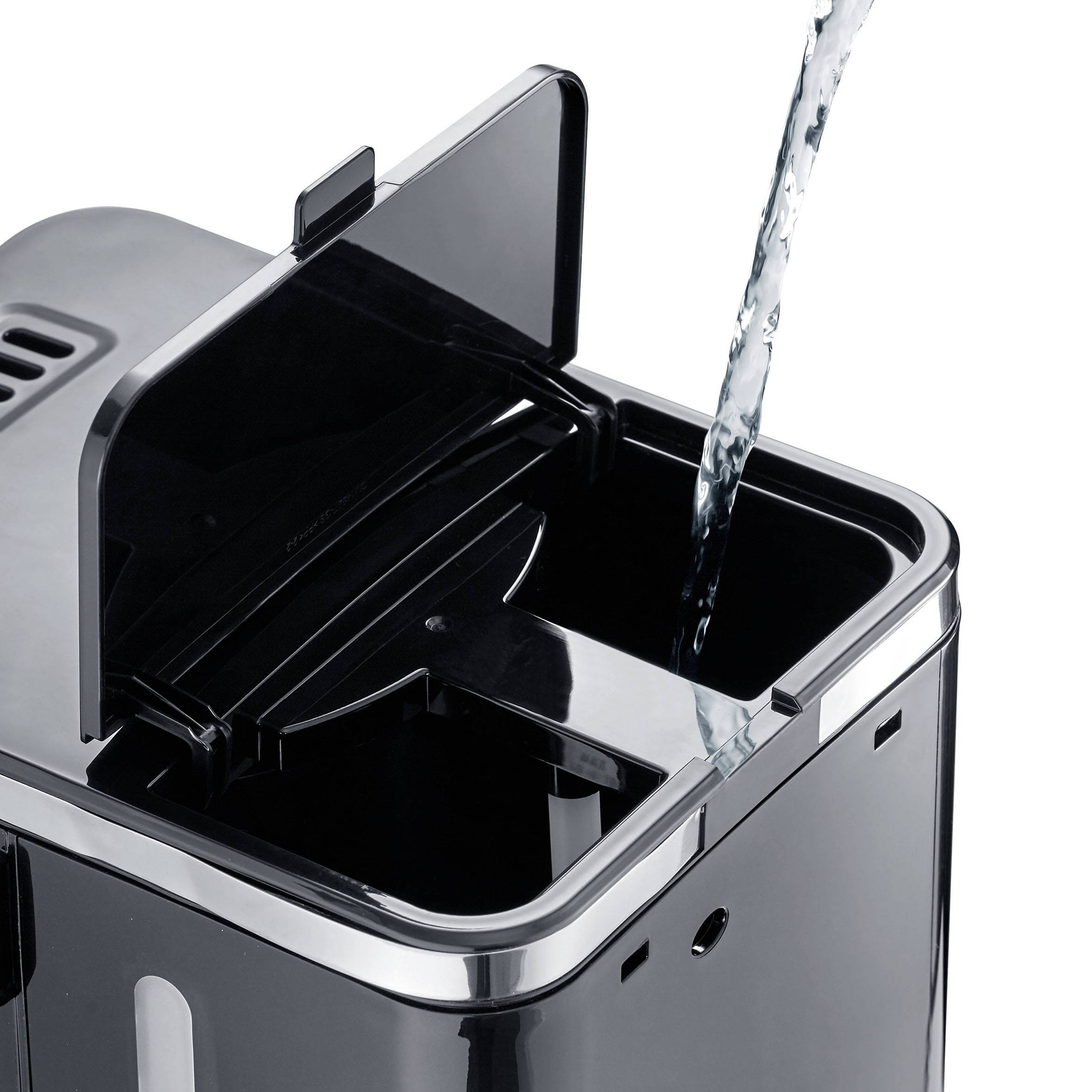 A water jet is being poured into an open black air humidifier.