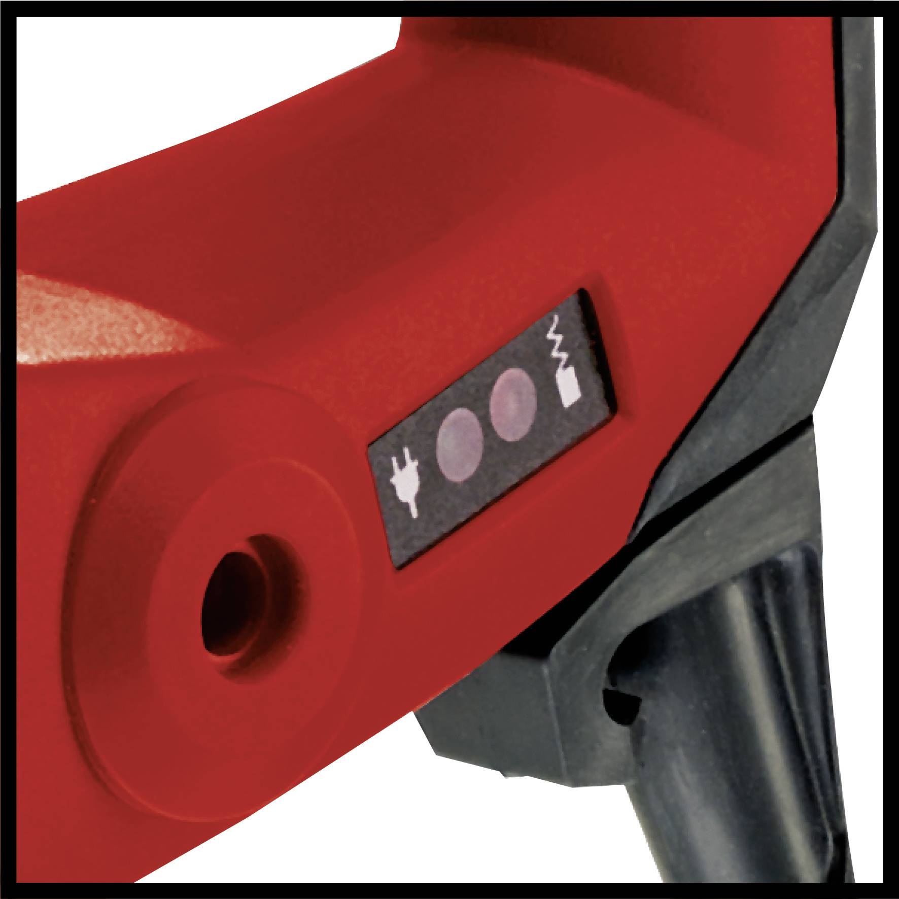 Close-up of a red housing with a black switch and symbols for electrical current and resistance, part of an electrical tool.