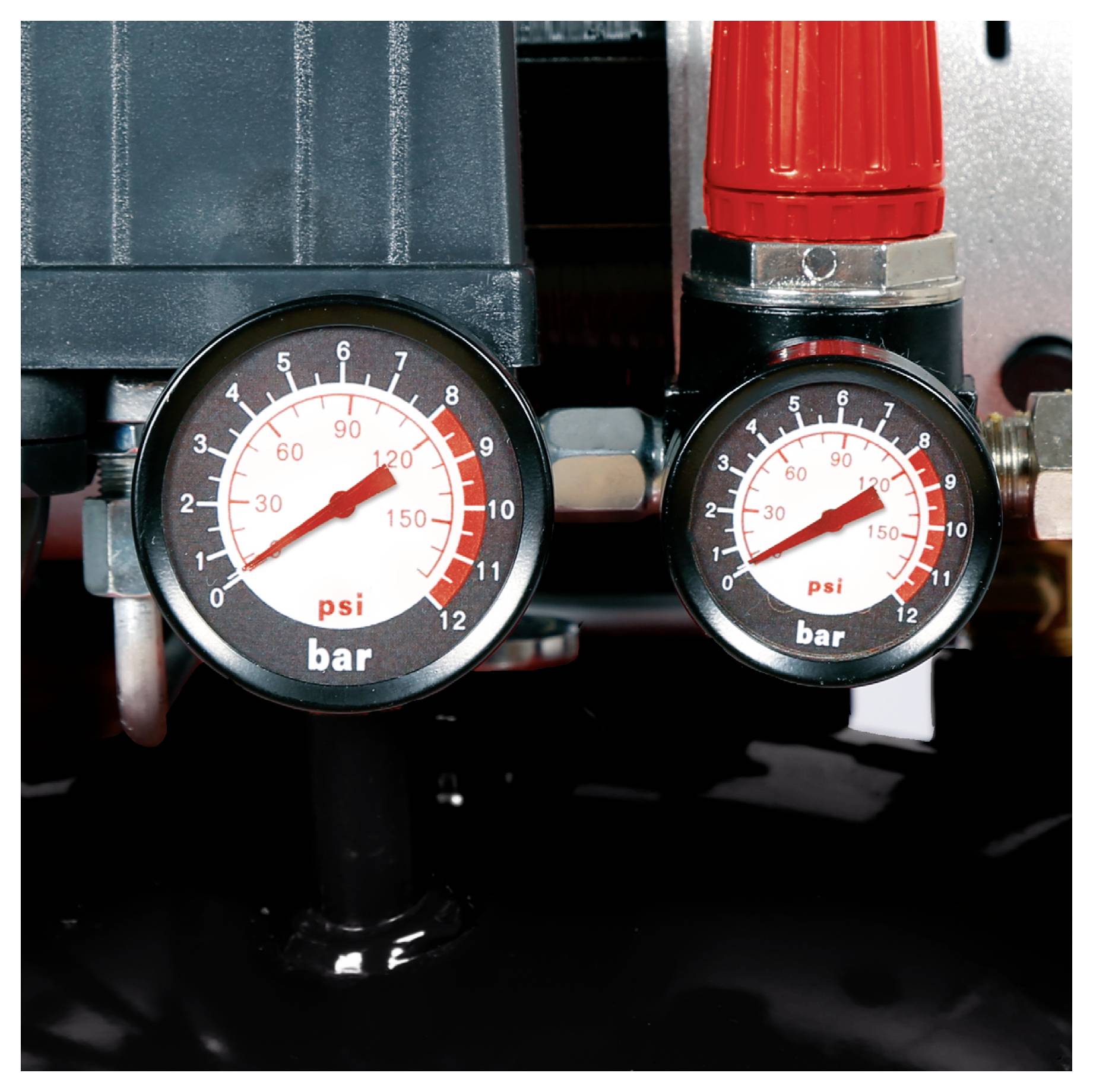 Two pressure gauges on industrial equipment display readings in bar and psi, with one larger gauge and one smaller gauge рядом a red fitting.