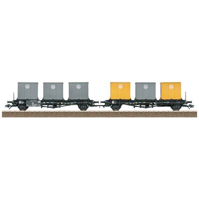 Model railway wagon with four container bodies, two grey with VW logo and two orange, on a piece of track.