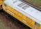 Yellow model of a locomotive on an outdoor track, detailed top view with ventilation grilles.