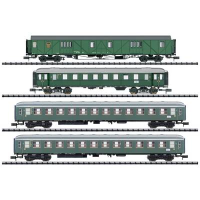 Four green model railway carriages in a row. Different designs and window arrangements. Railway tracks in the background.