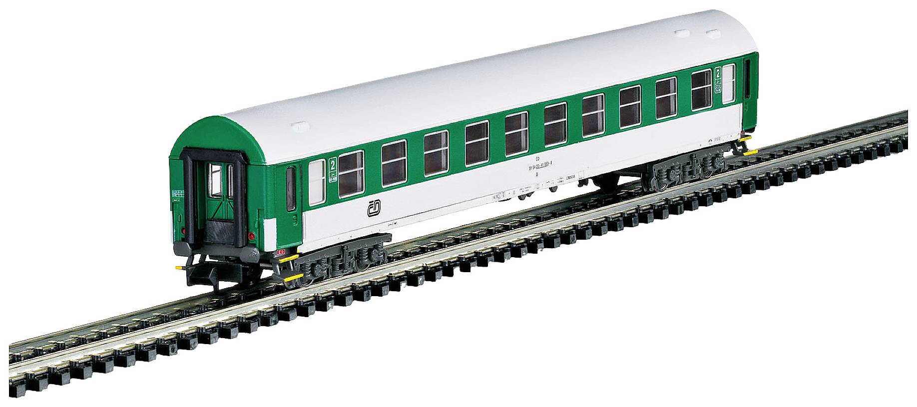 A model railway carriage at a scale of 1:87 on tracks, painted green and white, represents a typical passenger train wagon.