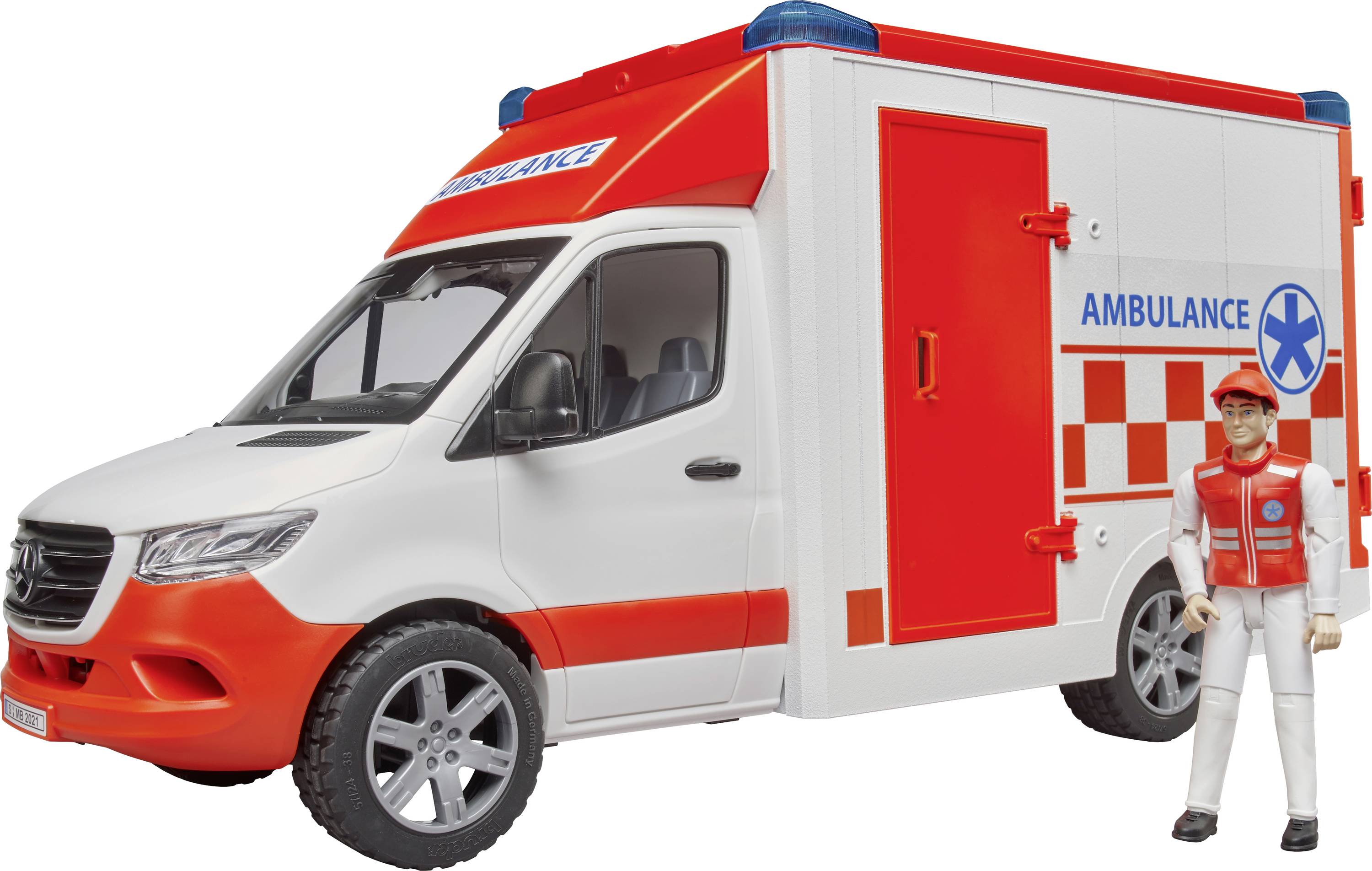 A toy ambulance with a red and white design. Beside it stands a figure wearing white clothing and a red vest.