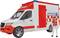 A toy ambulance with a red and white design. Beside it stands a figure wearing white clothing and a red vest.