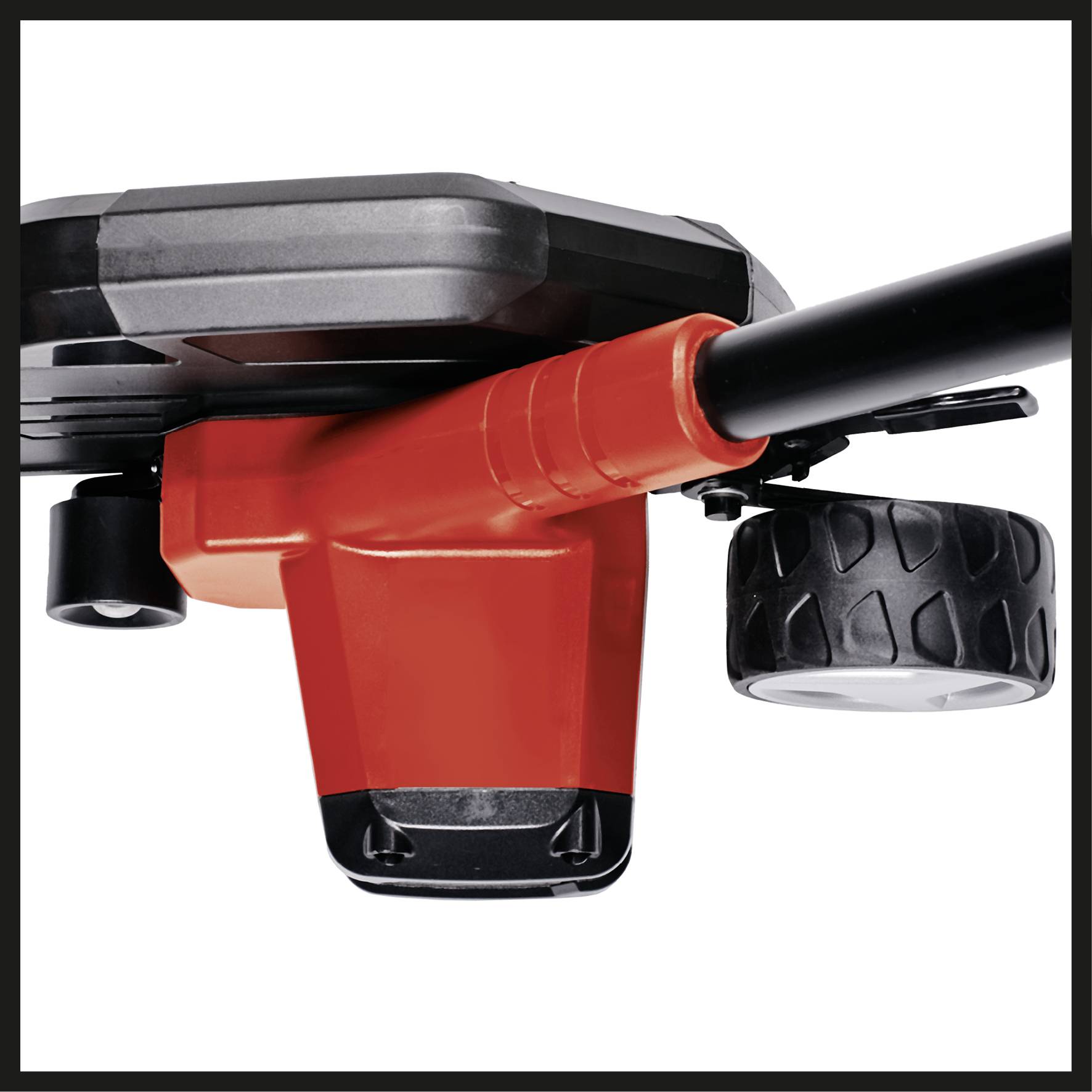 A red electric lawn trimmer with a black handle and black protective housing, resting on a ground wheel.