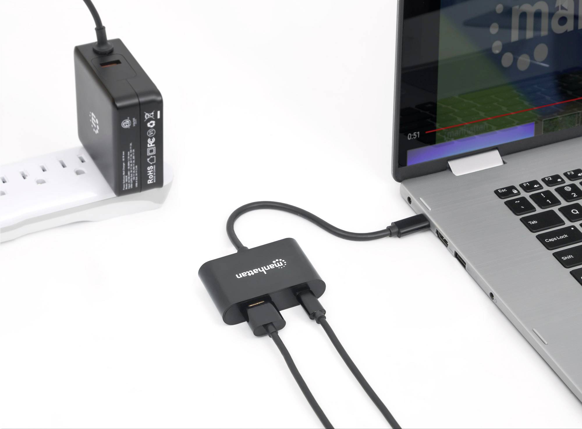 A laptop is connected via a USB hub with multiple cables, which is also plugged into a power socket.