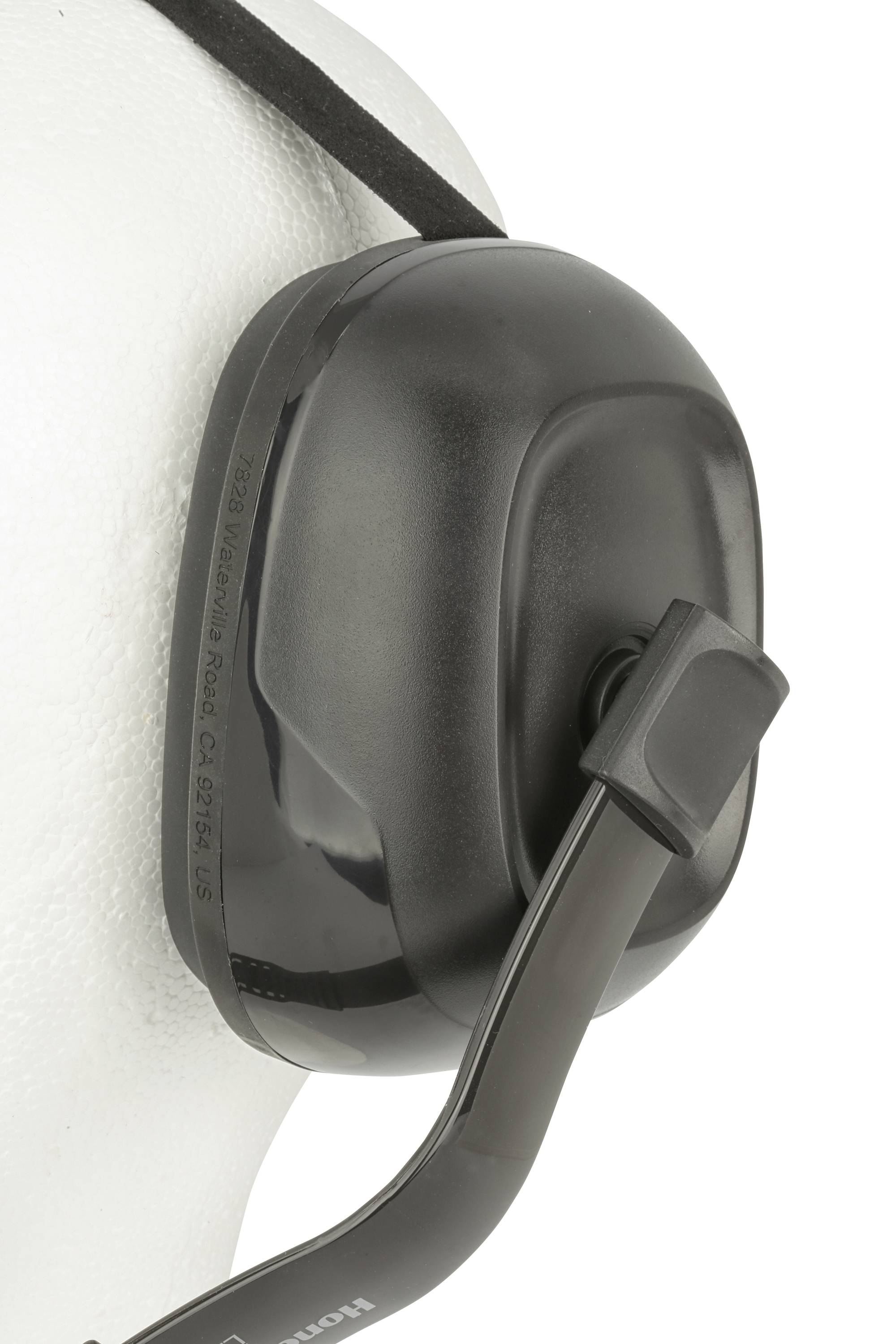 A black and grey ear defender on a white background, used to protect against loud noises.