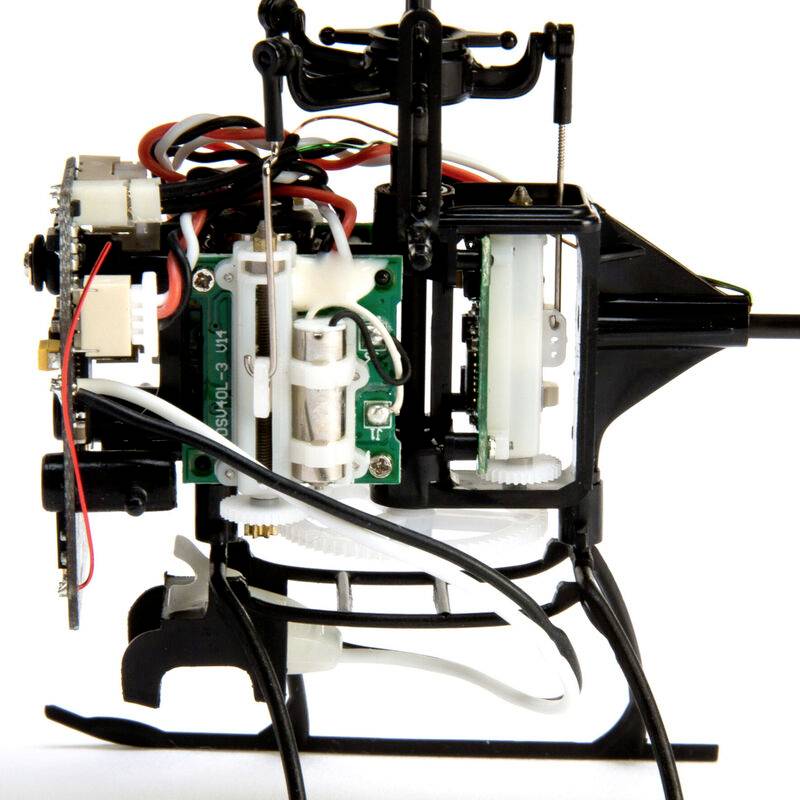 Close-up of a mechanical helicopter model without rotors, showing internal electronics and structure made of various metal components.