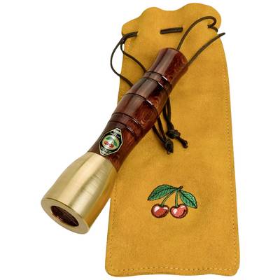 A wooden wind instrument with a metal end is resting on a yellow bag with an embroidered cherry motif.
