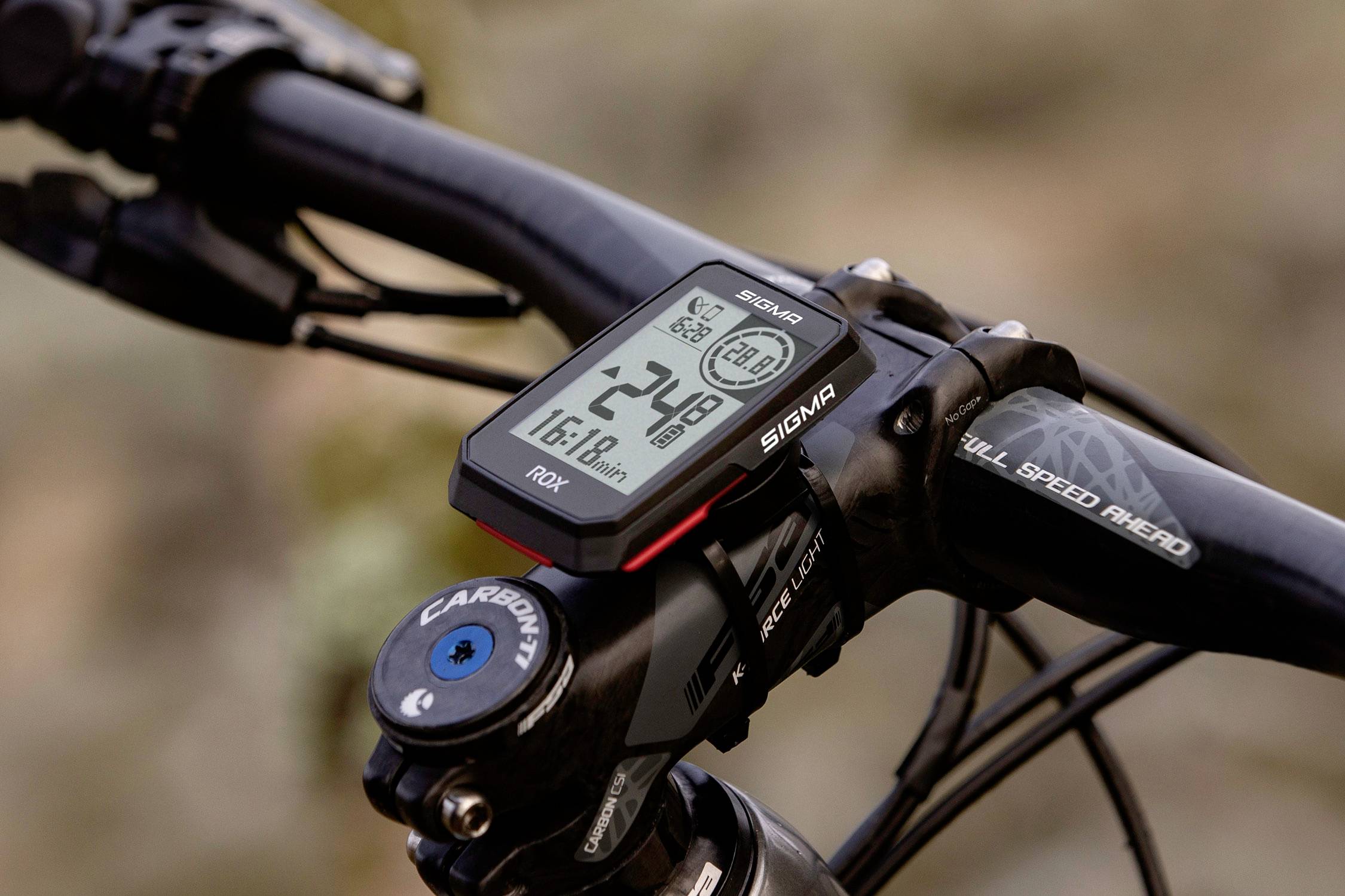 Bicycle handlebars with mounted bicycle computer; display shows speed 24.8 km/h, time 16:19, total distance.