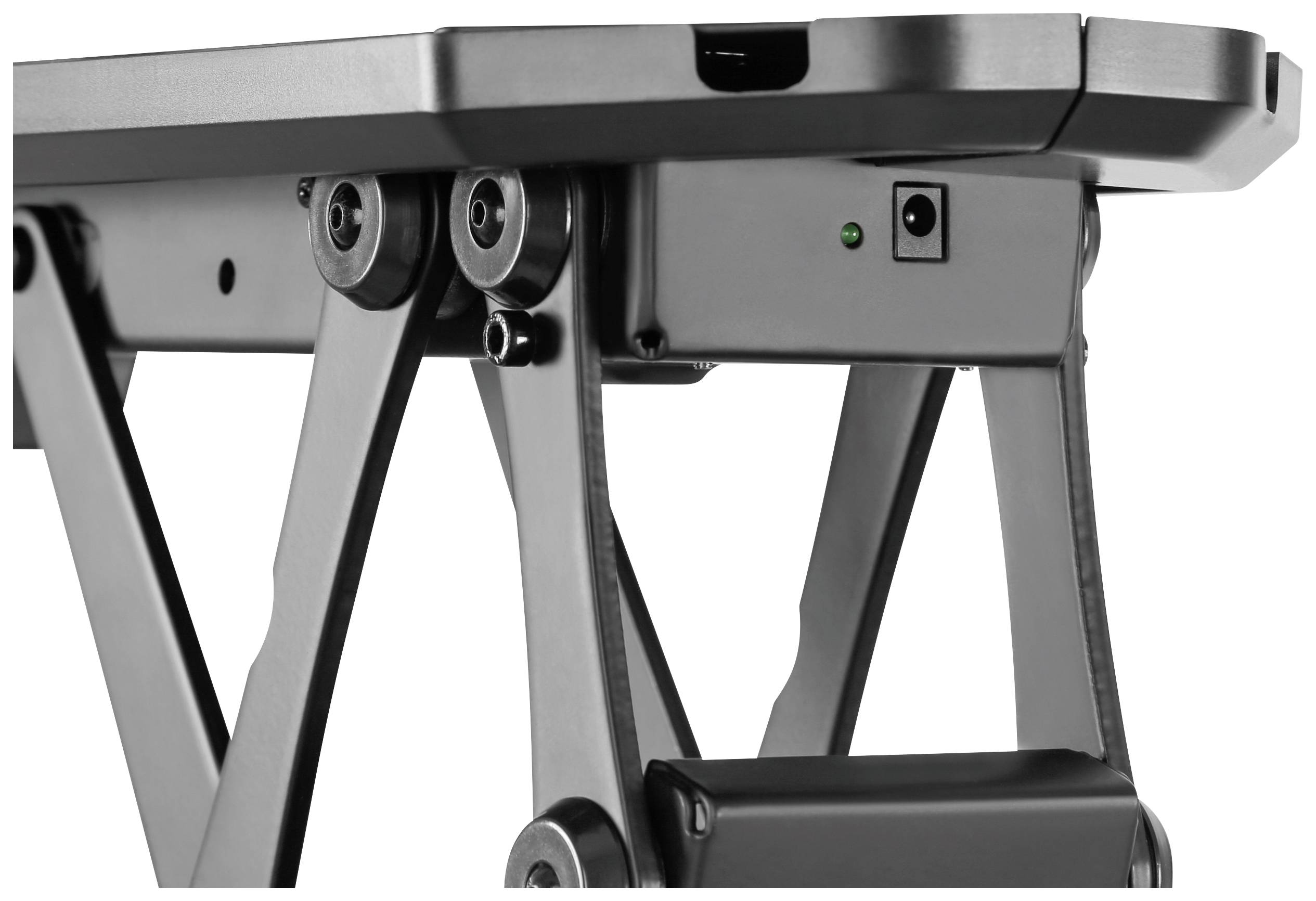An adjustable-height desk with black metal mechanics, electric control, and a visible green indicator light.