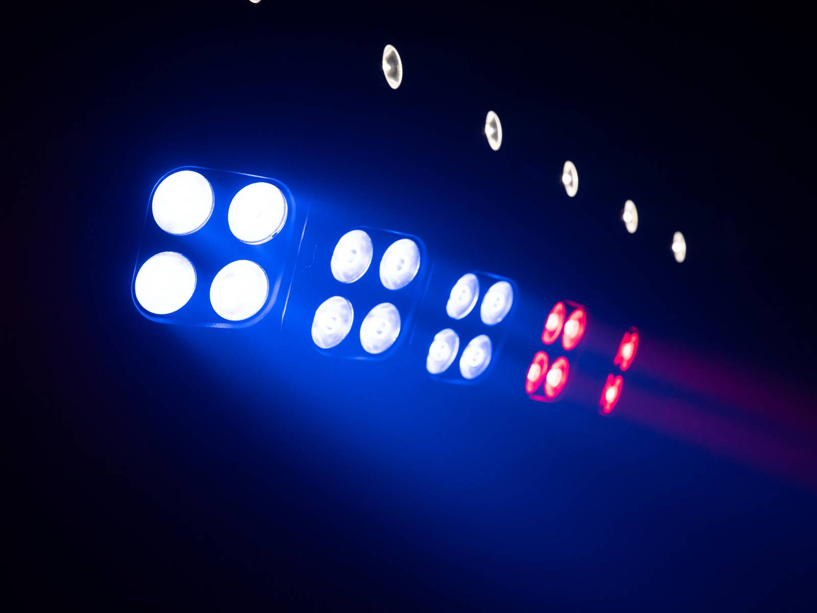 Blue and red lights illuminate on a race track, signalling the start of a race. Dark background with point lights.