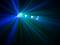 Colourful light rays stretch out across a dark room, with blue and green hues predominating. The effect of stage lighting.