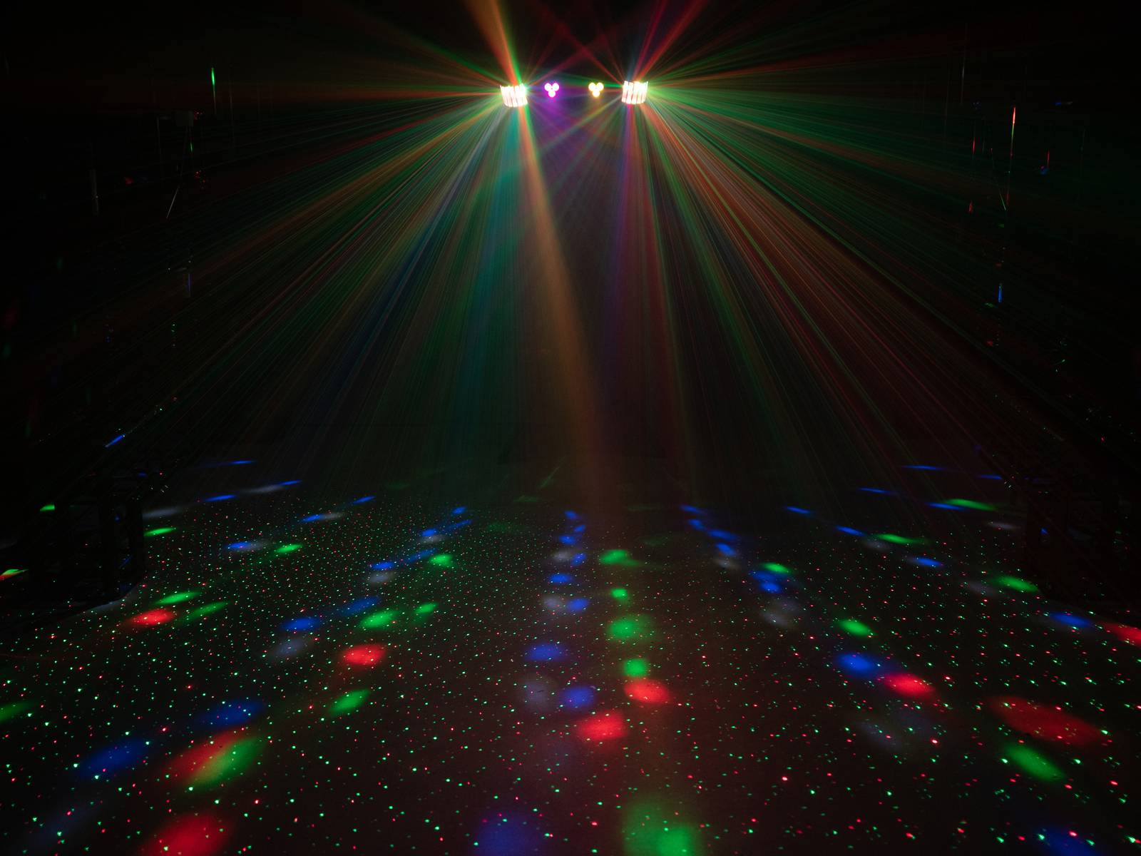 Disco lights create colourful rays and patterns on the floor, generating a vibrant party atmosphere.