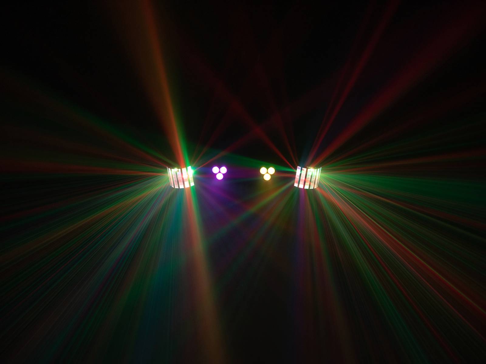 Colourful light beams emanating from multiple projectors in a dark room, spreading out in different directions.