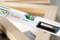 Spirit level with green vial for levelling; marked 'BOSCH Professional'. Resting on wooden beam.