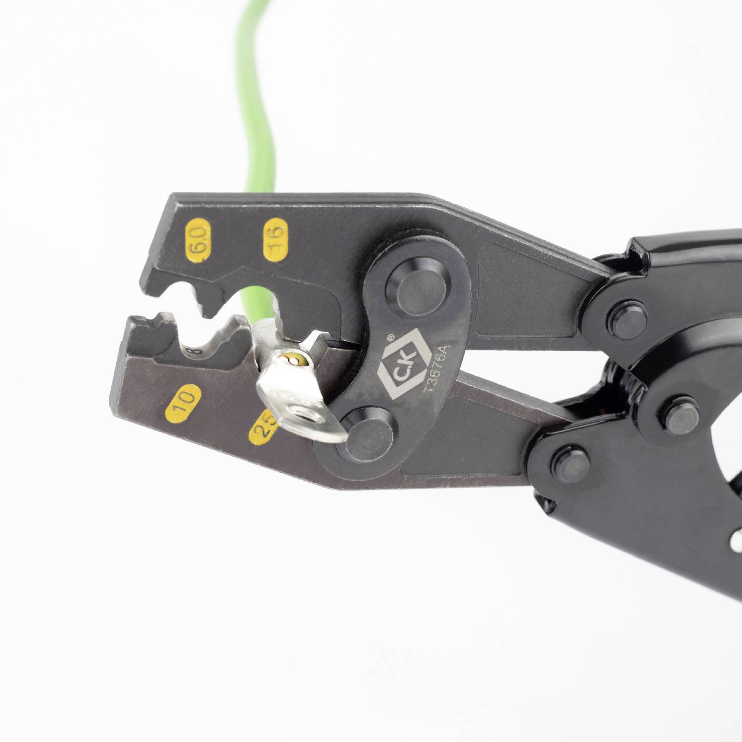 Wire strippers remove insulation from green wire. Tool for electrical work.