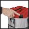A hand is pressing a red button on a locked, silver container with brackets around its edge.