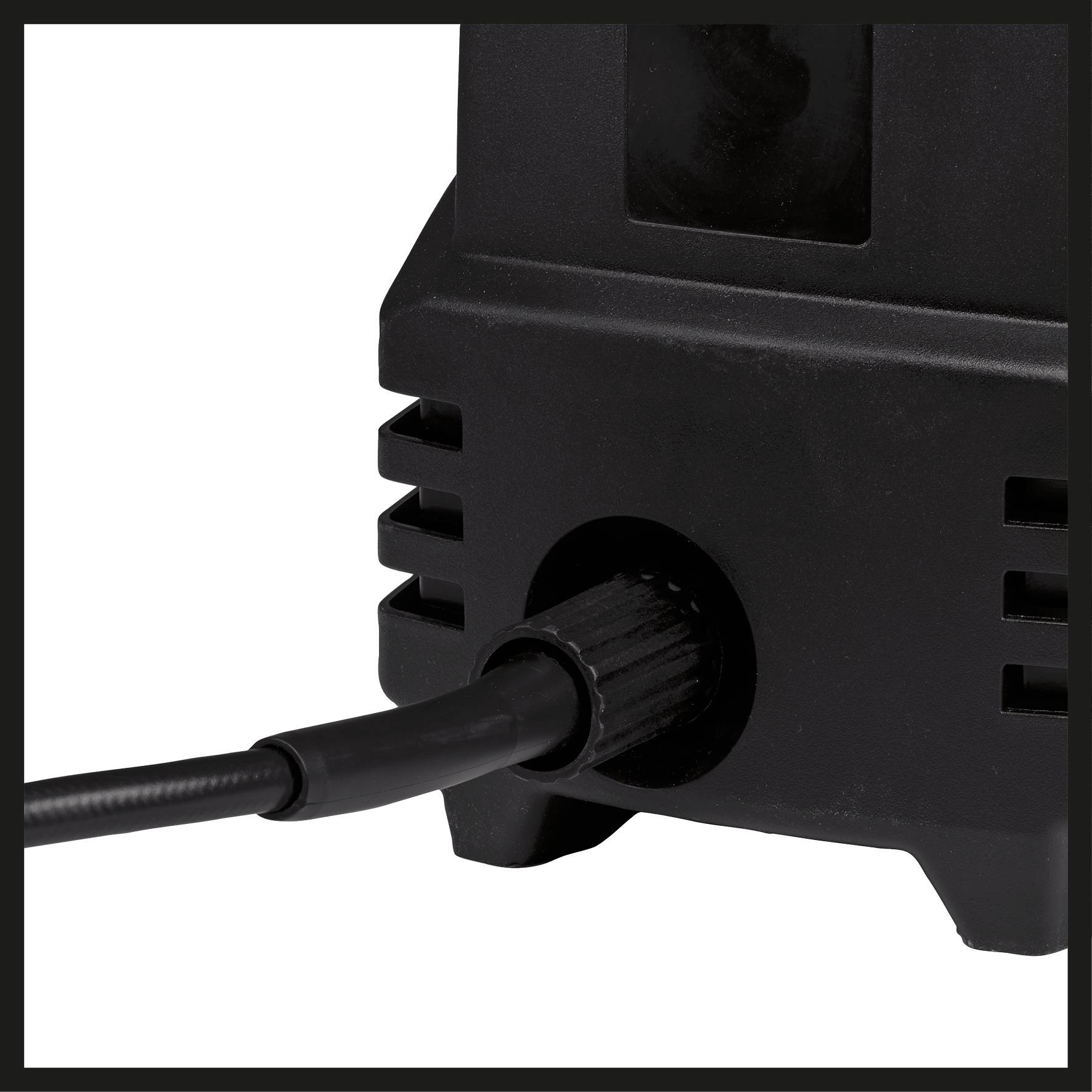 A black electrical device is connected to a cable. The socket is located on the side of the device.
