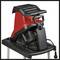 A red electric garden shredder stands on a black frame. It has a large input opening and a prominent control panel at the front.