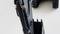 Close-up of a black excavator arm with a bucket and hydraulic hoses; parts of the caterpillar tracks are visible in the background.