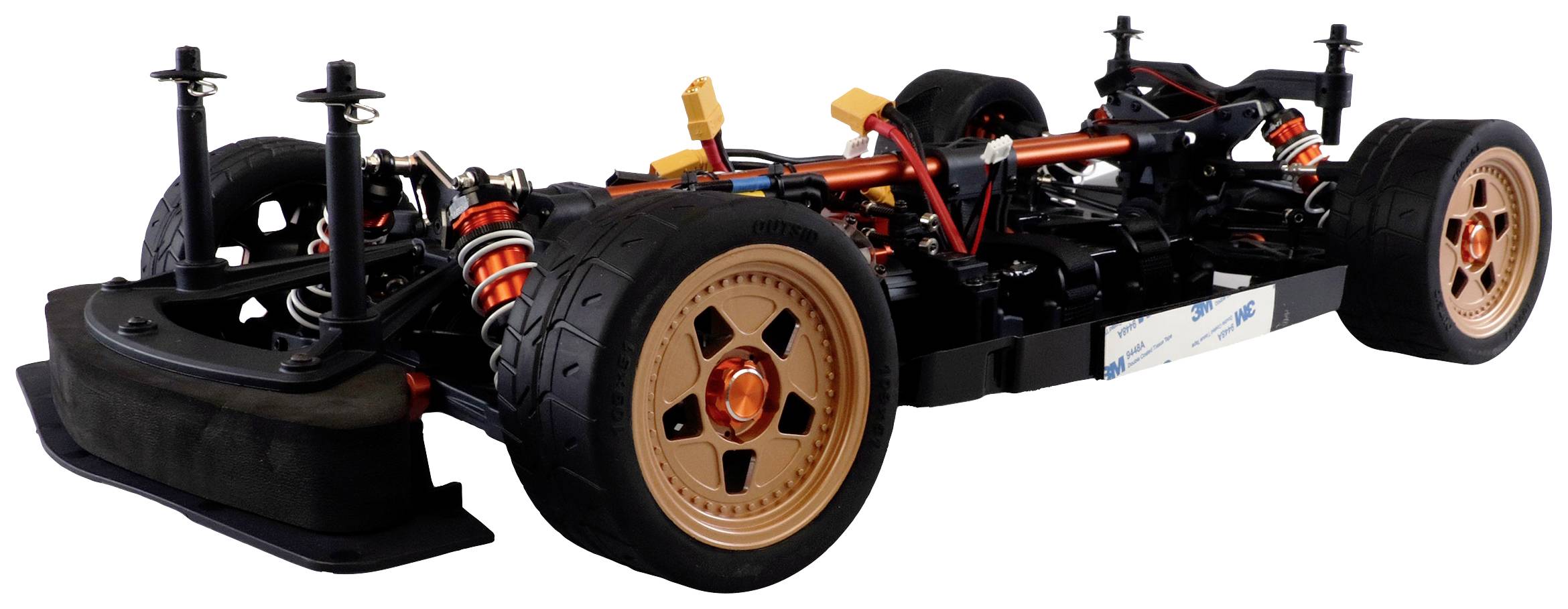A model car chassis with exposed mechanics, tyres and suspension, in a side view, reveals the details of its construction.